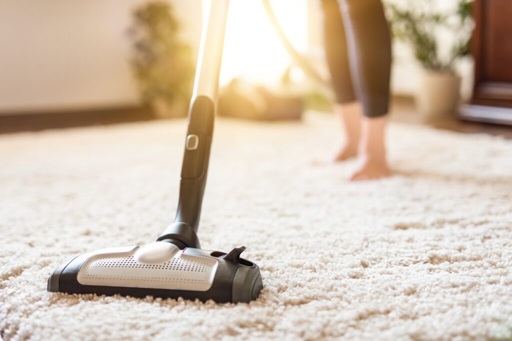 woman barefooted cleaning the carpet