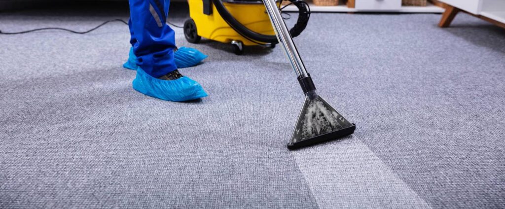 guy is cleaning the carpet of an office