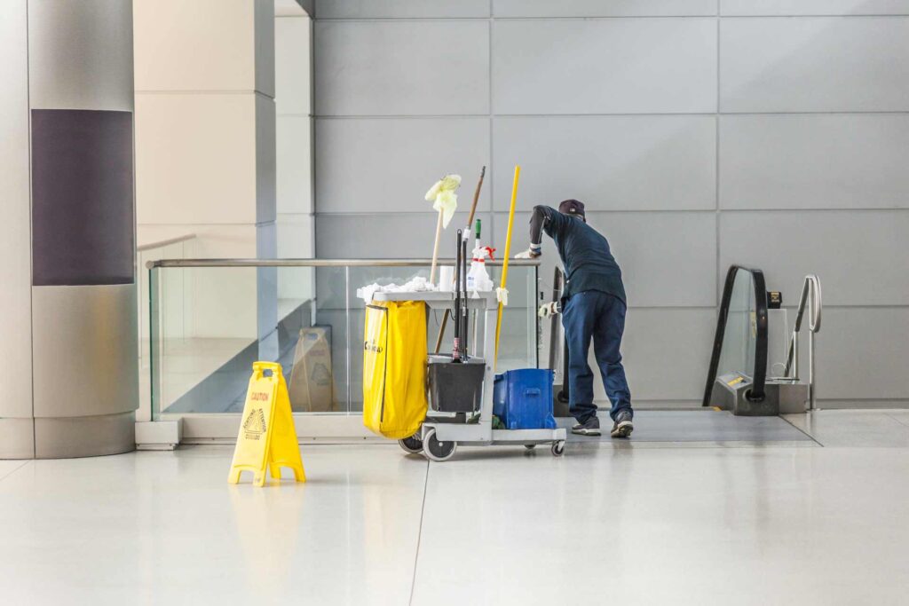 a guy with a plastic caddy to clean floors